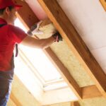 Worker installing insulation in an attic space